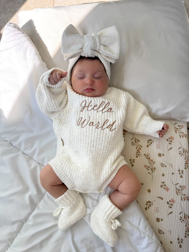 Newborn wearing Hello World romper — white knit baby romper with cursive hello world embroidery — Brave Little Lamb
