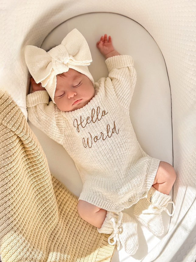 Newborn wearing Hello World romper — white knit baby romper with cursive hello world embroidery — Brave Little Lamb