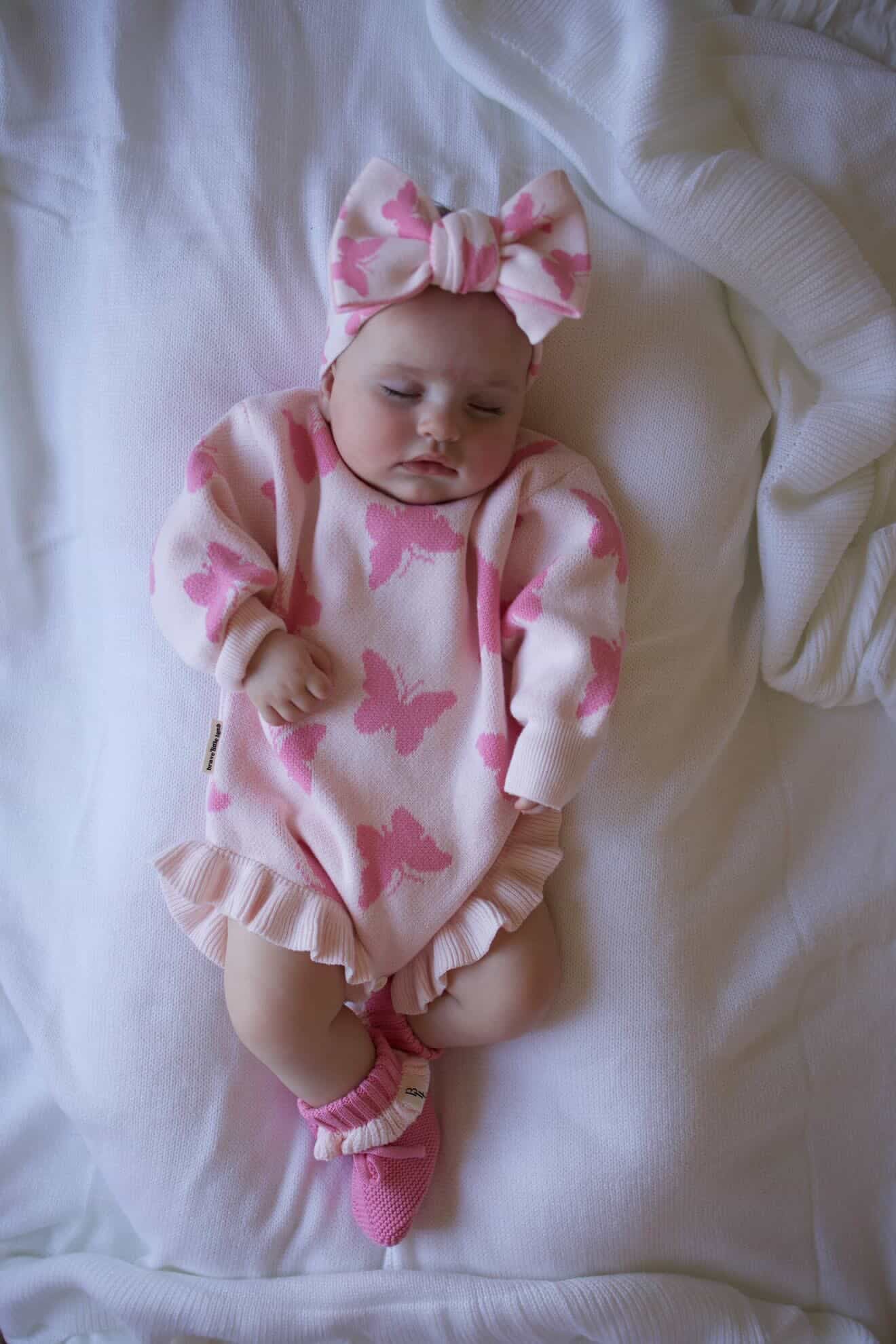 Baby wearing Flutter and Frills Knit Romper with bow — Brave Little Lamb