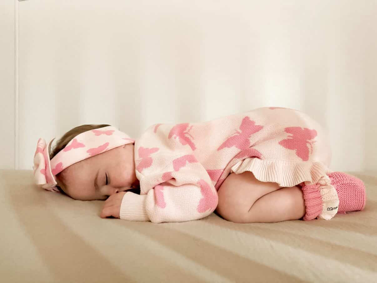 Baby sleeping in Flutter and Frills Knit Romper — Brave Little Lamb