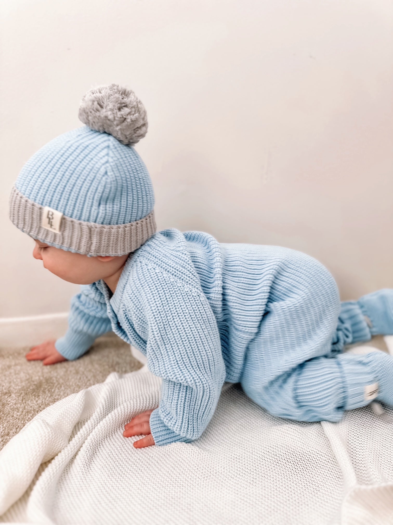 Baby crawling in blue Keepsake Knit Romper — Brave Little Lamb